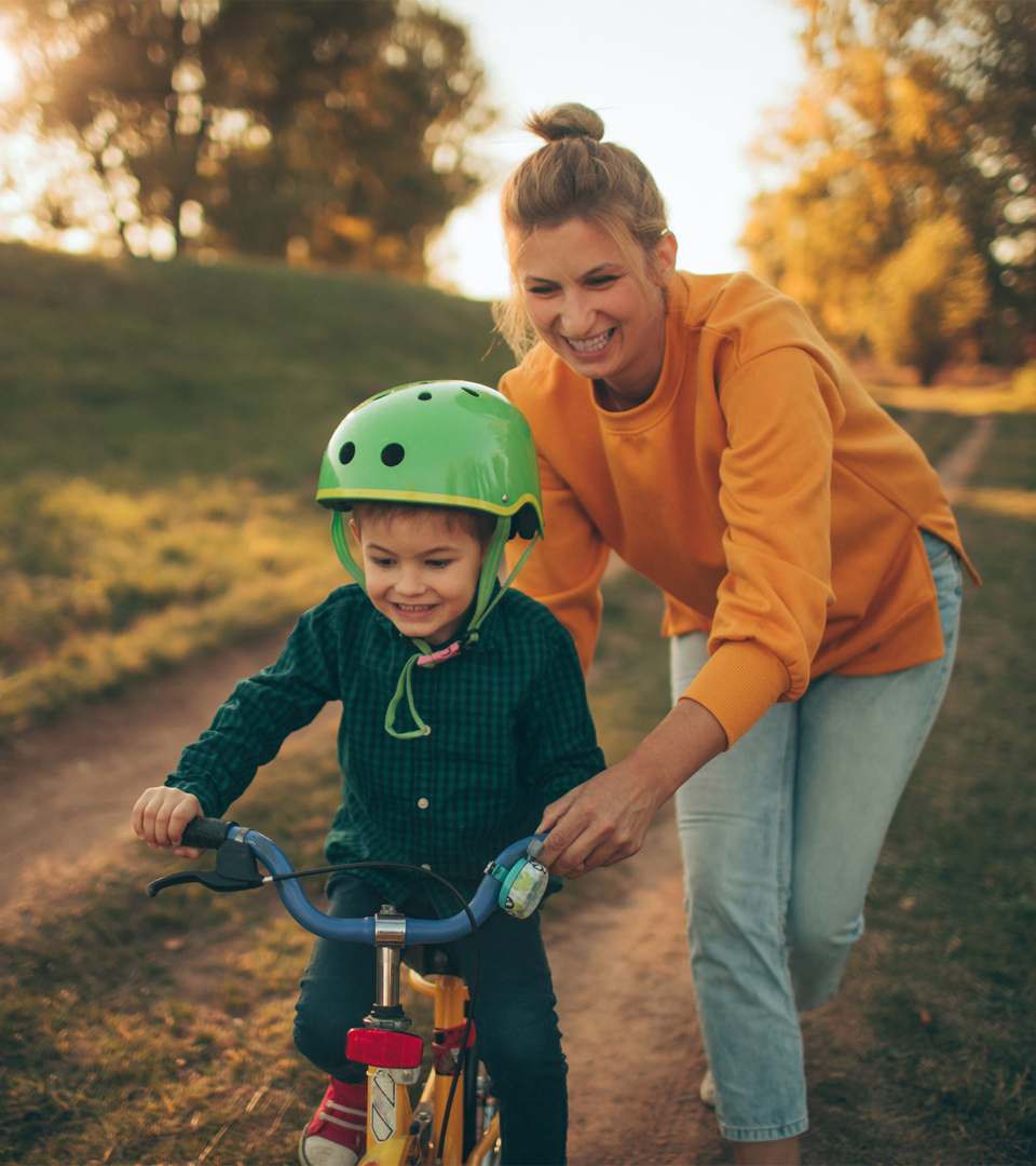 mother pushing child on bike